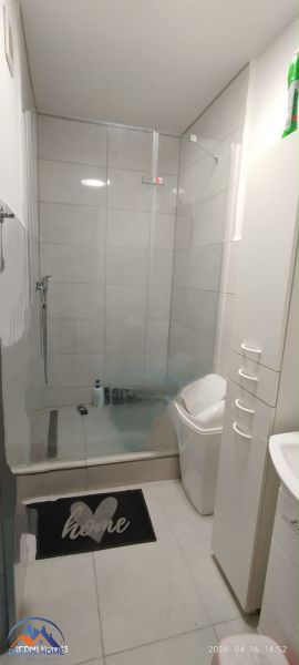 Badezimmer in einer 2-Zimmer-Wohnung mit geräumiger Dusche und weißen Möbeln.