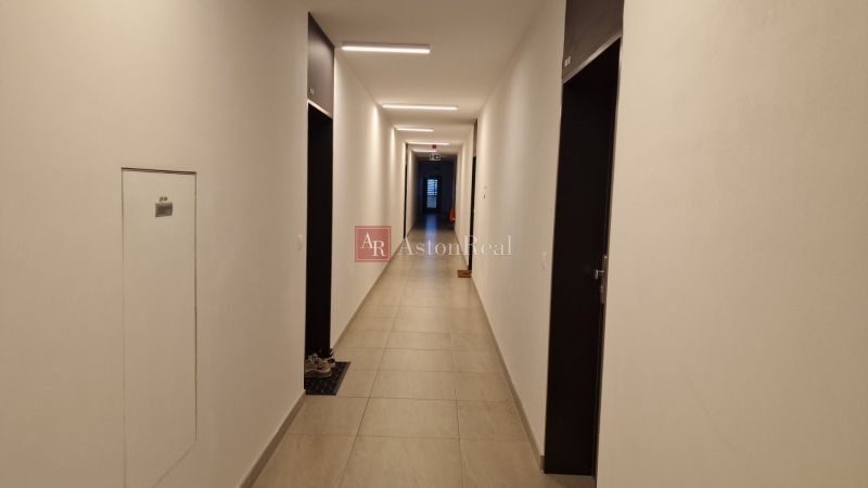 Der Flur in einer 2-Zimmer-Wohnung mit einfachem Interieur und Fliesenboden.
