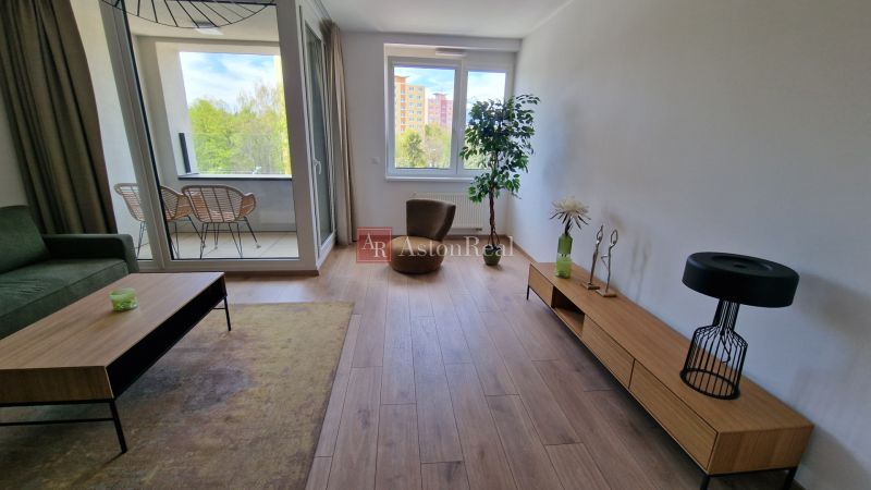 Wohnzimmer in einer 2-Zimmer-Wohnung mit Holzboden und großem Fenster.