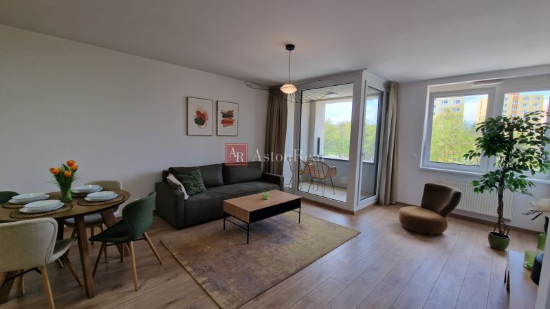 Wohnzimmer in einer 2-Zimmer-Wohnung mit Holzboden und verglaster Loggia.