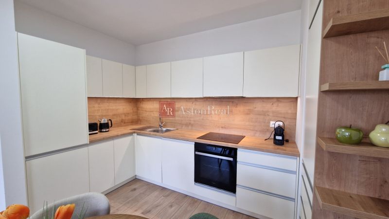 Küche in einer 2-Zimmer-Wohnung mit Holzdekor und eingebauten Geräten.