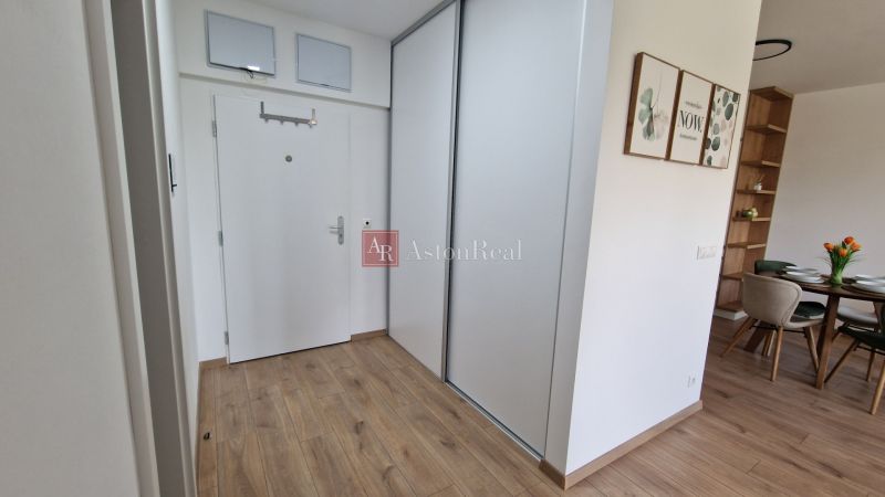 Innenraum einer 2-Zimmer-Wohnung mit Holzboden, weißen Türen und einem Essbereich.