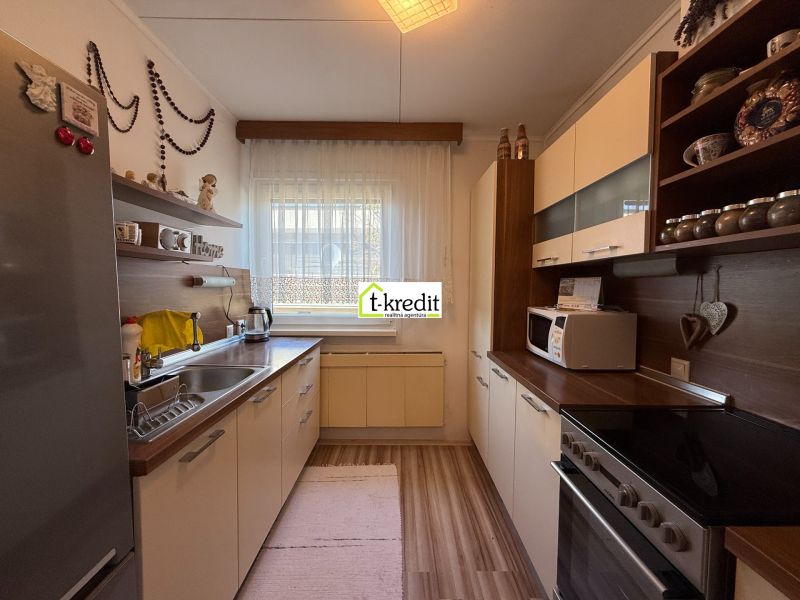 Eine Küche in einem Einfamilienhaus mit einem Holzboden und weißen Schränken.