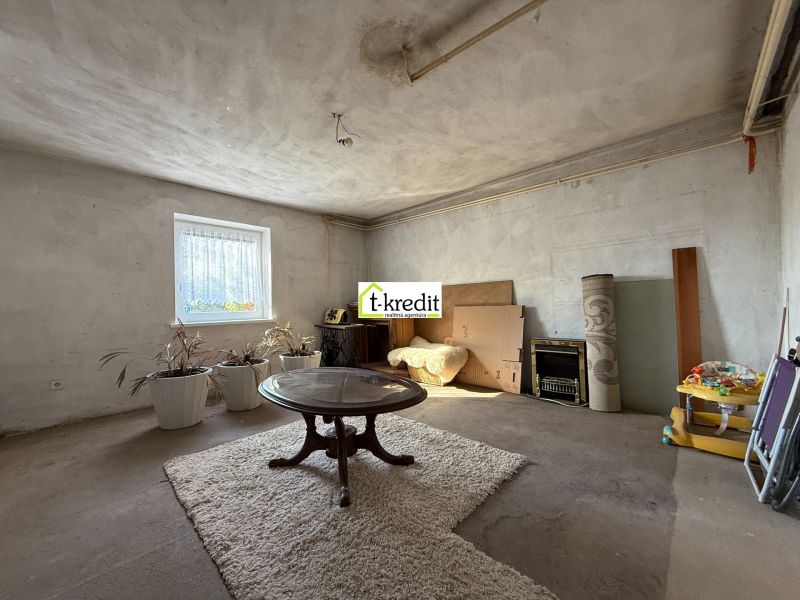 Wohnzimmer eines Einfamilienhauses mit einem ovalen Tisch und einem Teppich auf dem Boden.