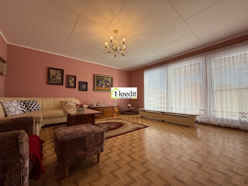 Wohnzimmer in einem Einfamilienhaus mit Holzboden und bequemen Sitzgelegenheiten.