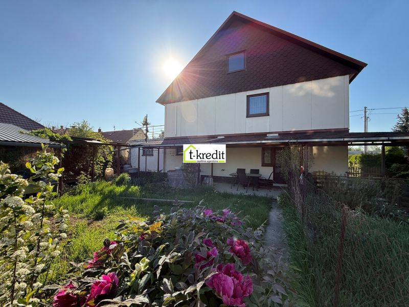 Ein Einfamilienhaus in Zlaté Moravce mit einem blühenden Garten und einem gepflegten Rasen.