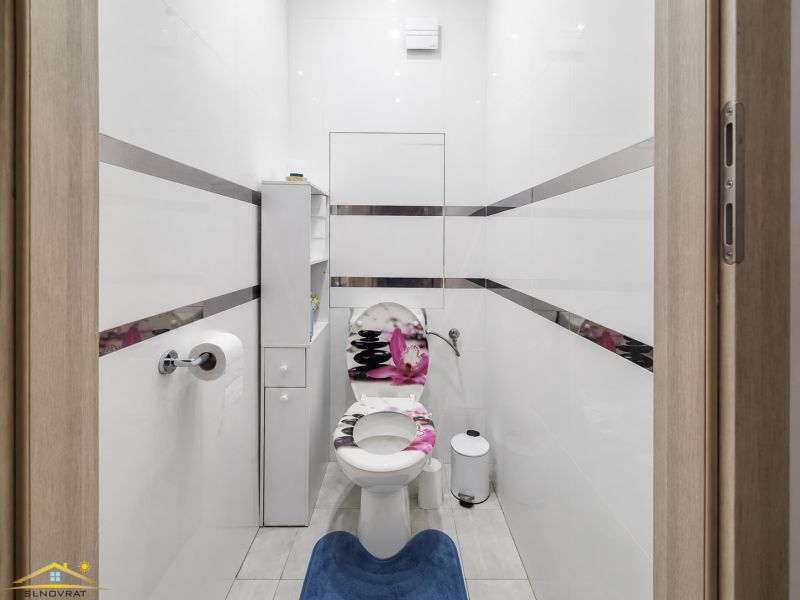 Ein Badezimmer in einer 3-Zimmer-Wohnung mit weißen Wänden und einer weißen Toilette.