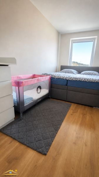 Schlafzimmer mit Kinderbett in einer 3-Zimmer-Wohnung, Boden mit Holzdekor.