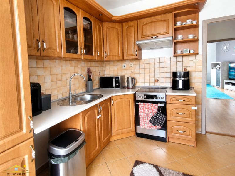 Küche in einer 3-Zimmer-Wohnung mit Holzelementen und Geräten.
