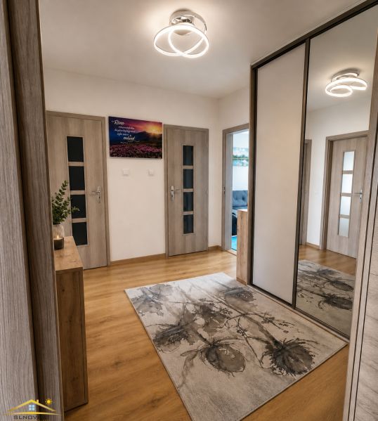 Der Flur in der 3-Zimmer-Wohnung mit einem Boden in Holzoptik und einem Spiegelschrank.