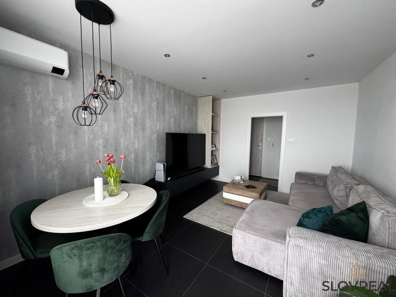 Wohnzimmer in einer 3-Zimmer-Wohnung mit einem bequemen Sofa und einem Esstisch.