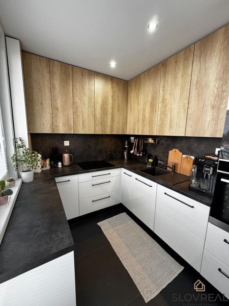 Küche mit weißen Schränken und Holzelementen in einer 3-Zimmer-Wohnung.