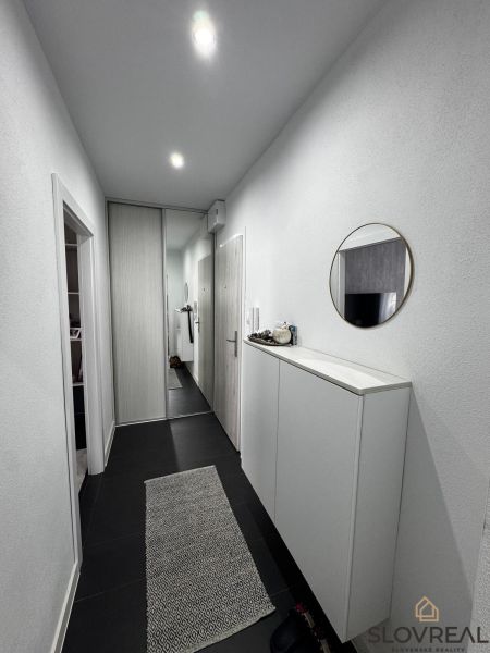 Der Flur in einer 3-Zimmer-Wohnung mit einem Spiegelschrank und einem dekorativen Teppich.
