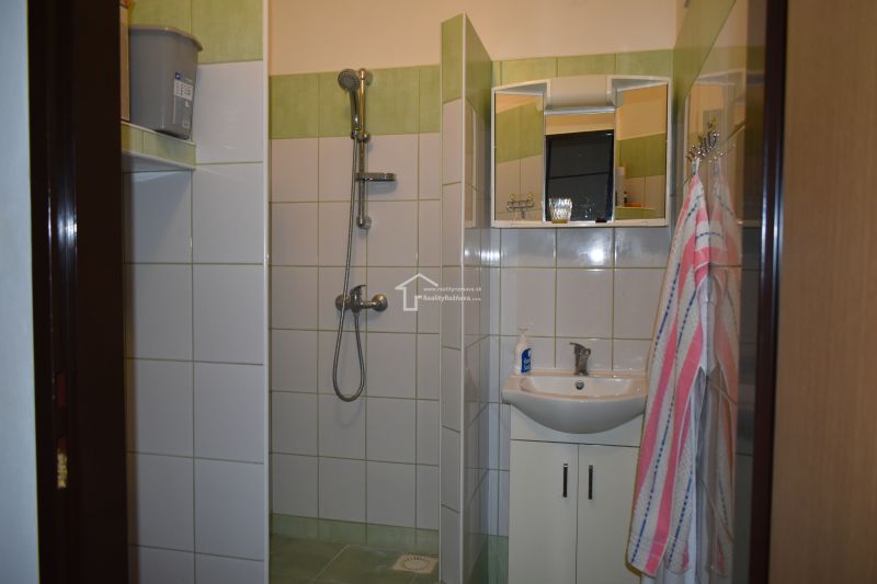 Badezimmer in einer 3-Zimmer-Wohnung mit Fliesen und Dusche.