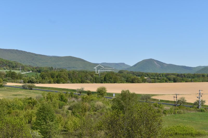 Die malerische Landschaft bei Rožňava mit Feldern, einer Straße und Hügeln in der Ferne.