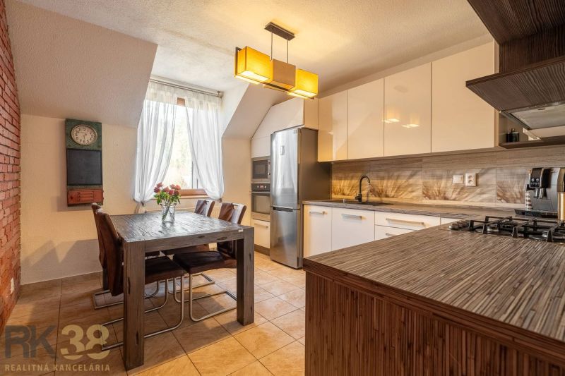 Küche in einer 4-Zimmer-Wohnung mit Esstisch, Kronleuchter und modernen Geräten.
