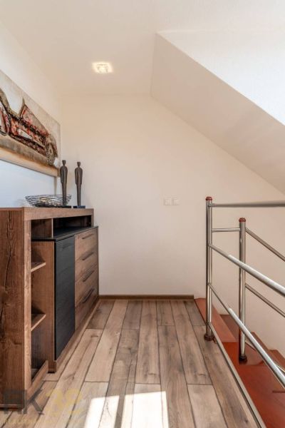Innenraum einer 4-Zimmer-Wohnung mit Holzboden, Metallgeländer und Dekorationen.