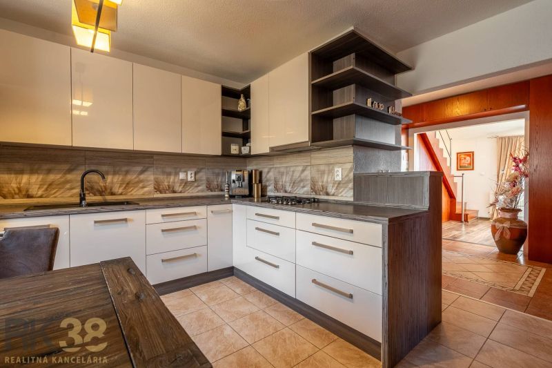 Küche in einer 4-Zimmer-Wohnung mit Holzboden und interessanter Beleuchtung.