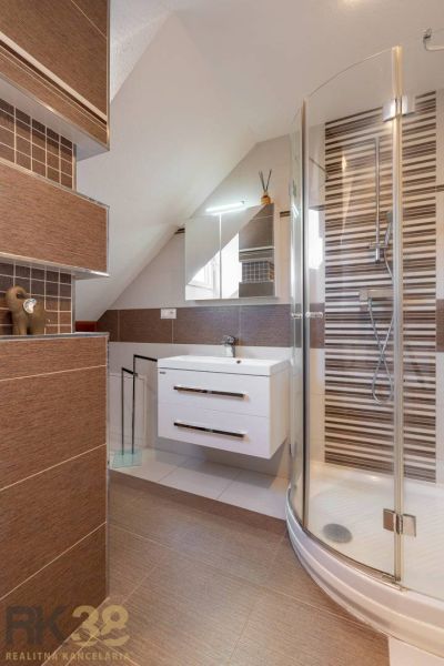 Badezimmer in einer 4-Zimmer-Wohnung mit eleganten Fliesen und Duschkabine.