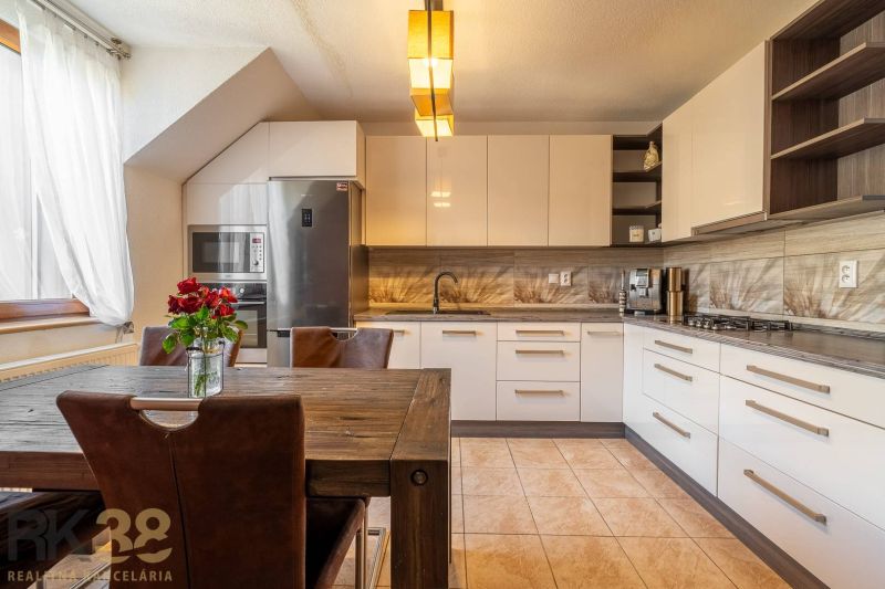 Moderne Küche mit Esstisch in einer 4-Zimmer-Wohnung mit Blumen auf dem Tisch.