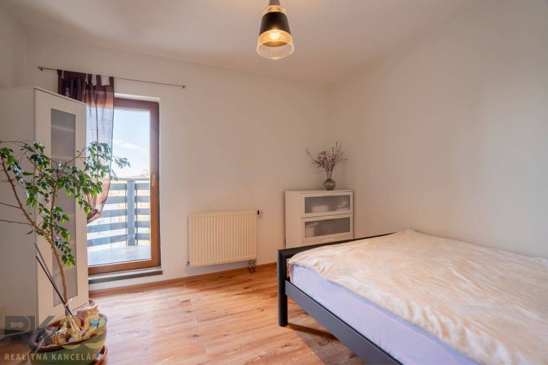Helles Schlafzimmer in einer 4-Zimmer-Wohnung mit Holzboden, Pflanze und Balkon.