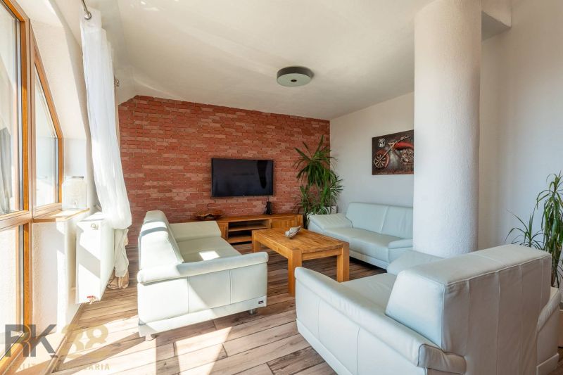 Wohnzimmer in einer 4-Zimmer-Wohnung mit Ziegelwand und Holzboden.