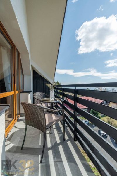 Ein Balkon mit Rattan-Sitzmöbeln und Blumendekoration in einer 4-Zimmer-Wohnung in Vyšné Hágy.