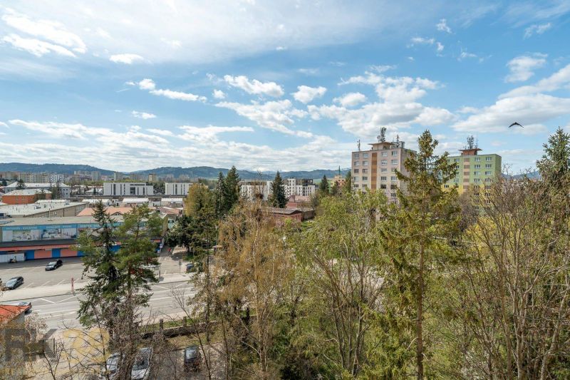Ein Blick auf Wohnhäuser, umgeben von Grünflächen und der Straße Partizánska in Poprad.