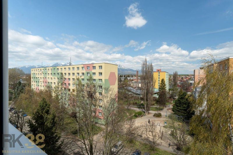 Blick aus einer 4-Zimmer-Wohnung in der Partizánska-Straße in Poprad auf die umliegende Grünfläche und die Wohnblöcke.