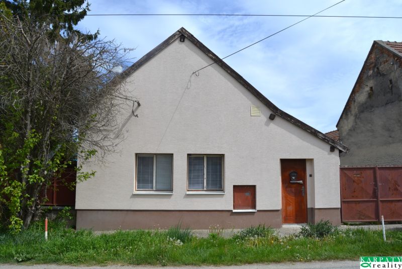 Ein Einfamilienhaus in Horné Saliby mit einer einfachen Fassade und einem Vorgarten.