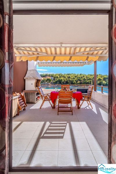 Ferienwohnung Brač mit Terrasse, Meerblick und Außenstühlen am Tisch.