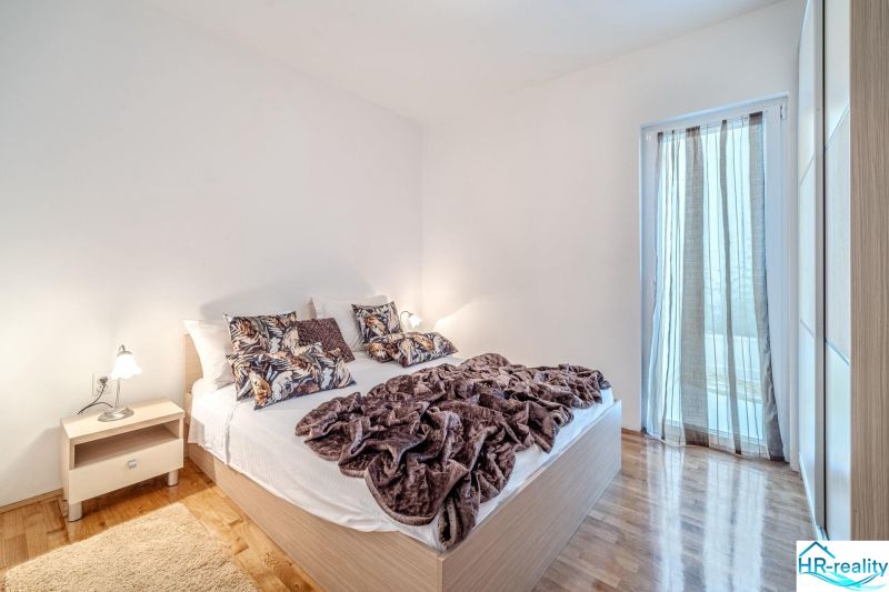 Helles Schlafzimmer mit Bett und Holzboden in der Ferienwohnung.