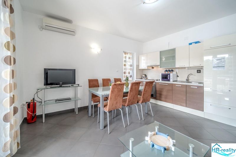 Helle Küche mit Esstisch und Fernseher in einer Ferienwohnung.