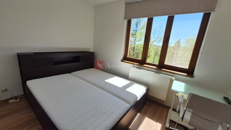 Schlafzimmer mit Doppelbett, Holzboden und Fenster im Ferienapartment.