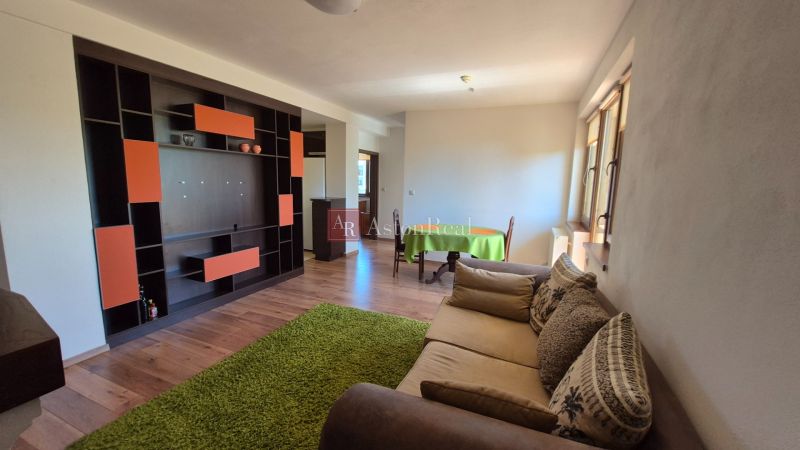 Ferienwohnung mit Holzboden, Sofa und bunter Wandgestaltung.