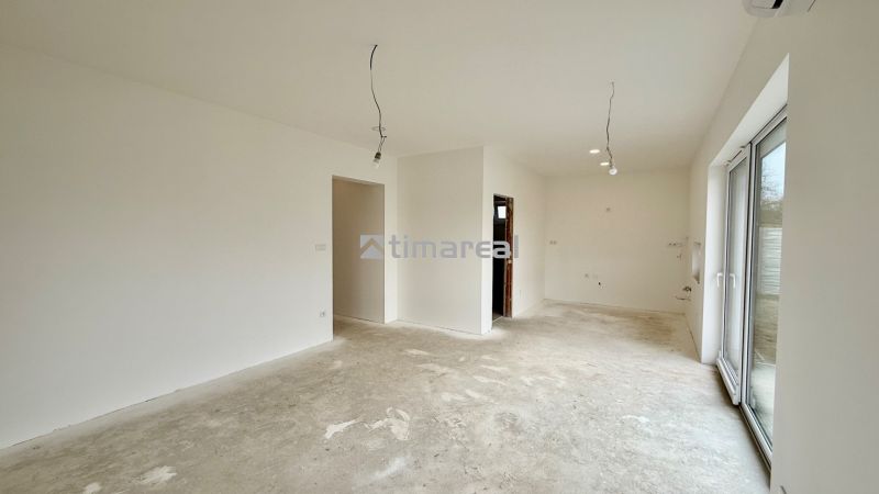 Geräumiges Zimmer mit Gipsputz und großen Fenstern in einem Einfamilienhaus.