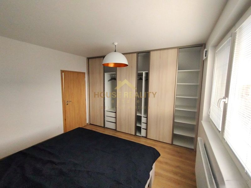 Schlafzimmer in einer 2-Zimmer-Wohnung mit Holzboden und Einbauschrank.