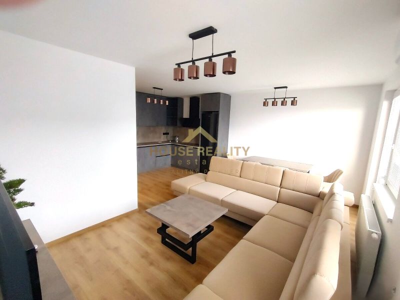 2-Zimmer-Wohnung mit Holzboden, heller Couch und Kochnische.