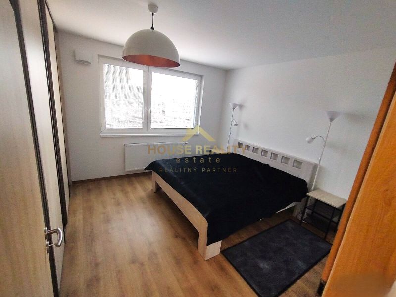 Schlafzimmer mit Doppelbett, Lampen und Holzboden in einer 2-Zimmer-Wohnung.