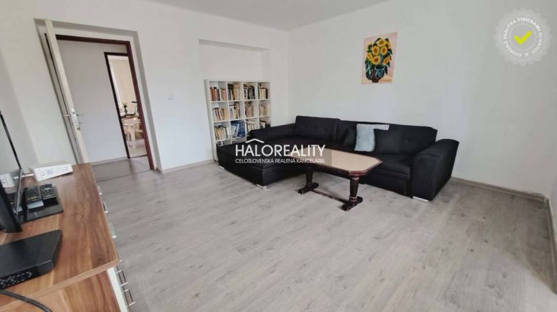 Wohnzimmer in einer 3-Zimmer-Wohnung mit Holzboden und bequemer Couch.