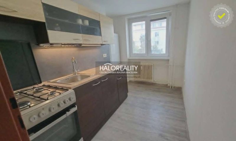 Küche in einer 3-Zimmer-Wohnung mit einem Gasherd und einem Boden in Holzoptik.
