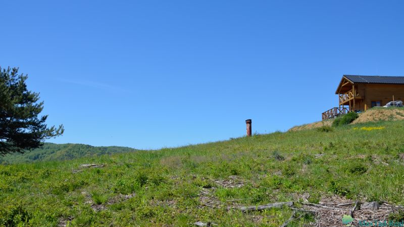 Eine Holzhütte in den Erholungsgebieten von Nová Kelča, umgeben von grüner Natur.