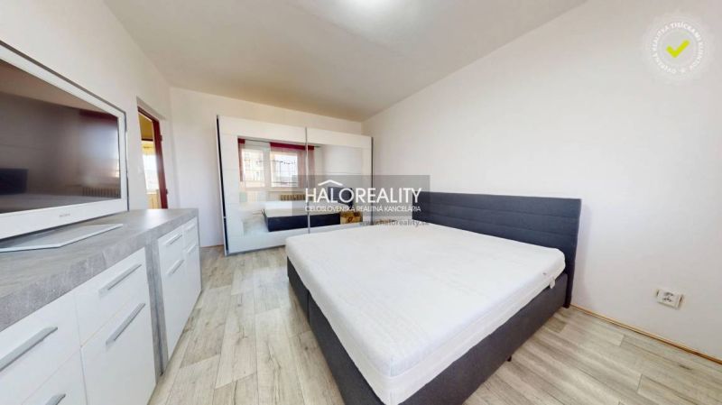 Schlafzimmer in einer 2-Zimmer-Wohnung mit Holzboden und Kleiderschrank.