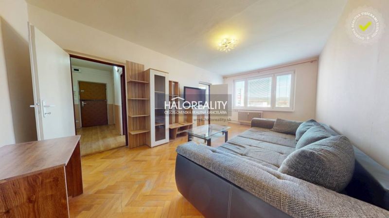 Wohnzimmer mit Holzboden, Sofa und Möbeln in einer 2-Zimmer-Wohnung.