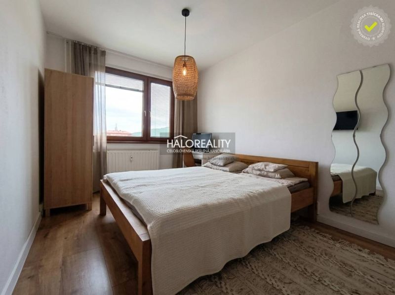 Schlafzimmer in einer 3-Zimmer-Wohnung mit einem Bett und einem Boden in Holzoptik.