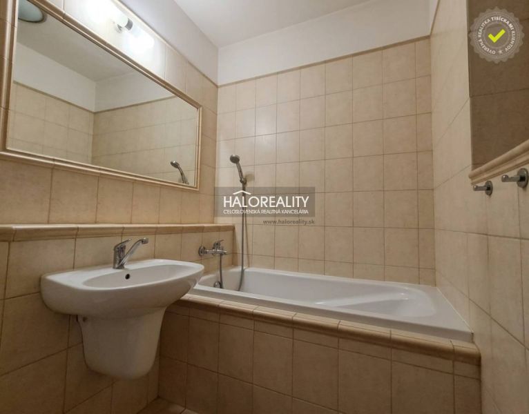 Badezimmer in einer 3-Zimmer-Wohnung mit Badewanne, Waschbecken und einem großen Spiegel an der Wand.