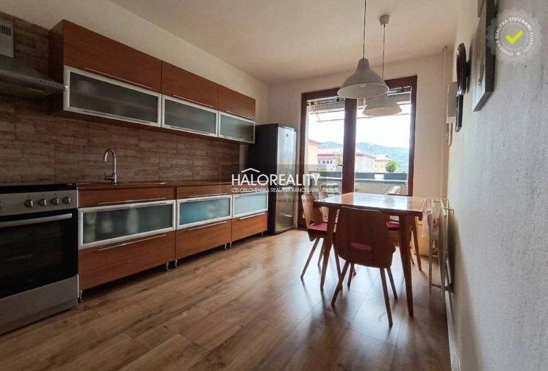 Küche in einer 3-Zimmer-Wohnung mit Holzboden und Esstisch.