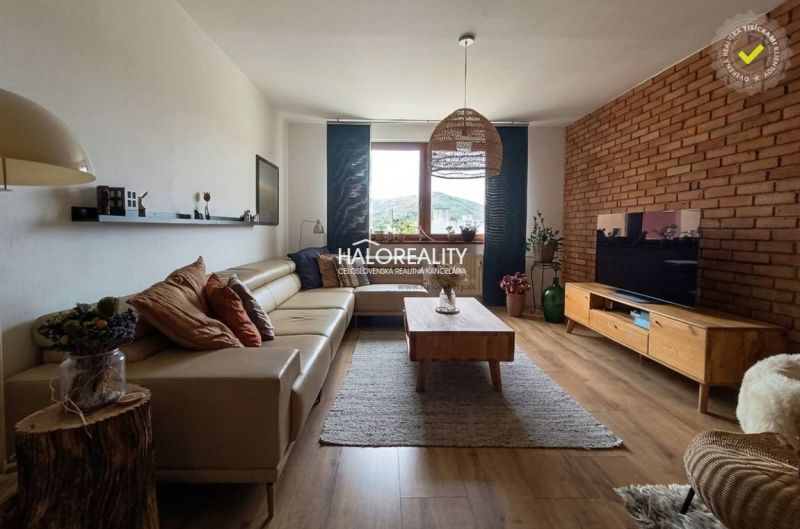 Wohnzimmer mit Ledersofa, Fernseher und Holzboden in einer 3-Zimmer-Wohnung.