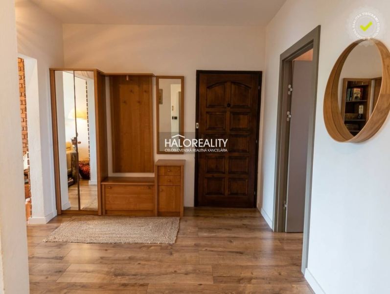 Diele in einer 3-Zimmer-Wohnung mit einem Boden in Holzoptik und Holzschränken.
