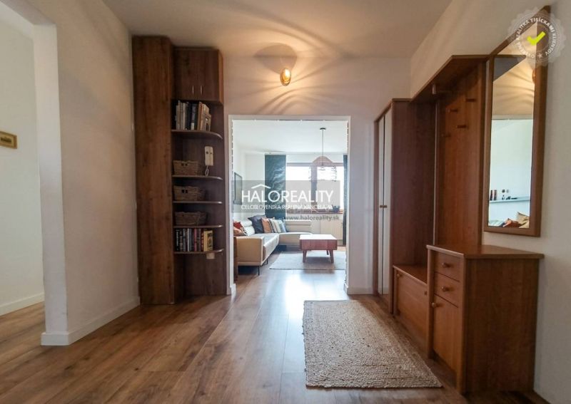 Eingangshalle in einer 3-Zimmer-Wohnung, Boden mit Holzdekor, Bücherregal, helles Wohnzimmer.